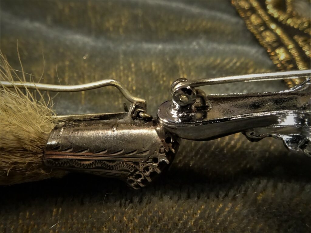 Two grouse claw pins. A Victorian clasp on the left and a modern clasp on the right
